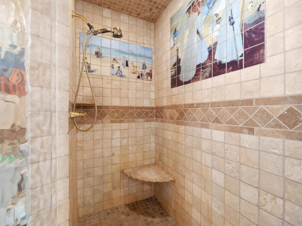 Bathroom with a shower and tile walls.