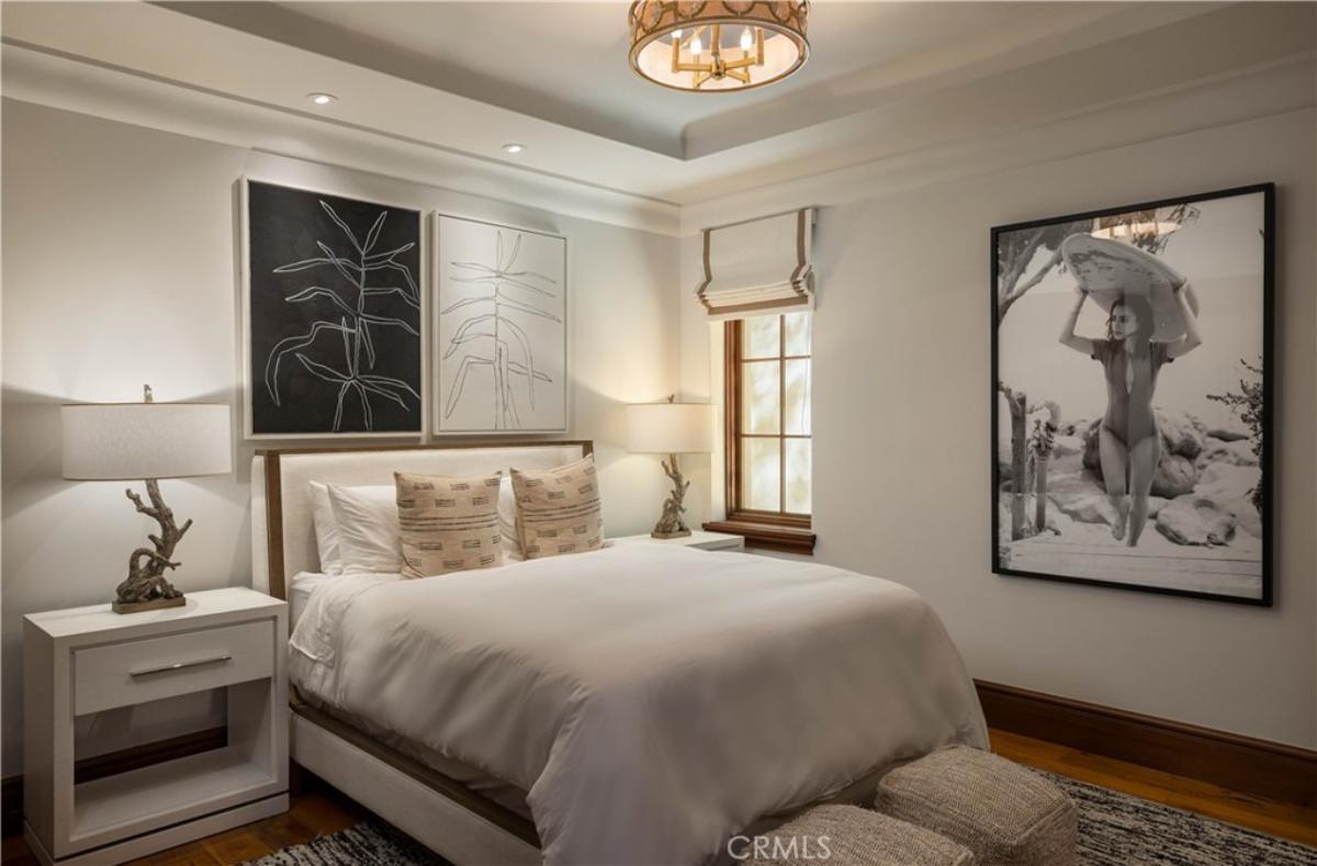 Bedroom with a large bed, chandelier and custom lights.