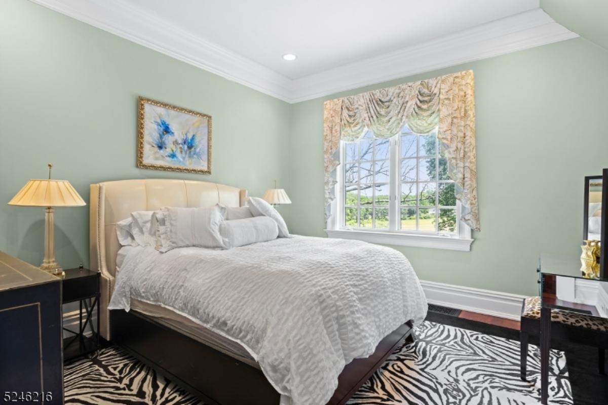 Bedroom with a large bed, glass windows and carpet flooring.