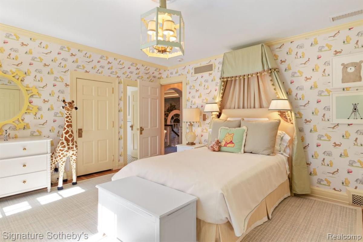 Bedroom with a large bed, chandelier and a large rug.