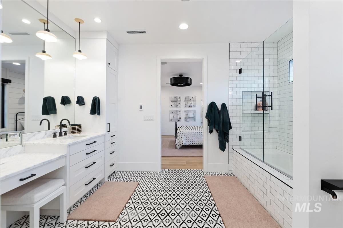 Bathroom with a sink, mirror and a walk-in shower.