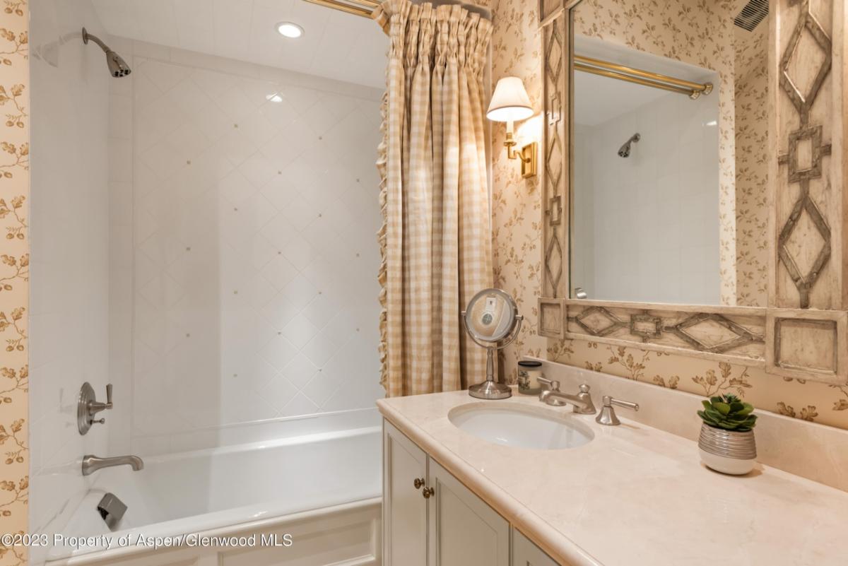 Bathroom with a sink, mirror, soaking tub and a shower.