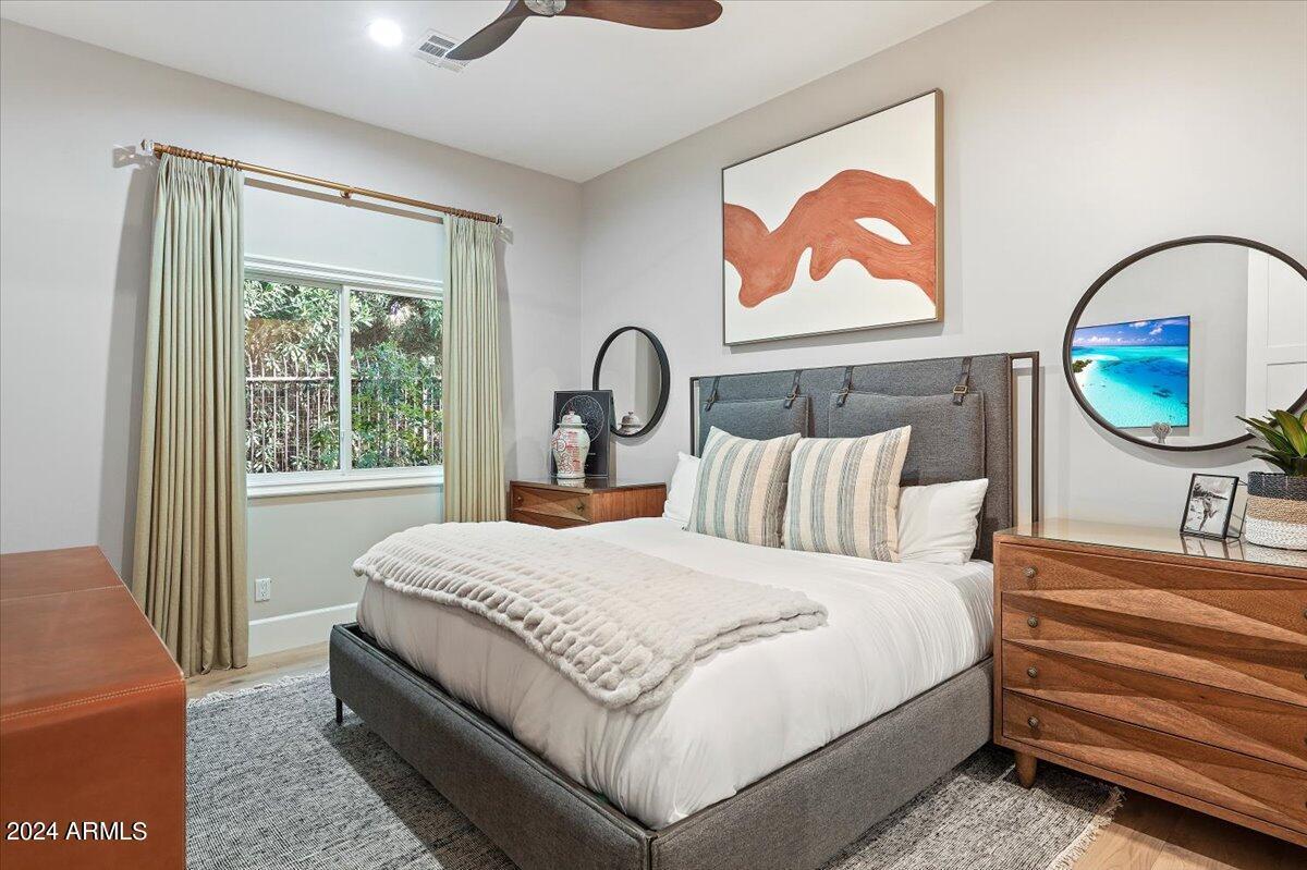 Bedroom with a large bed, glass windows and large rug.