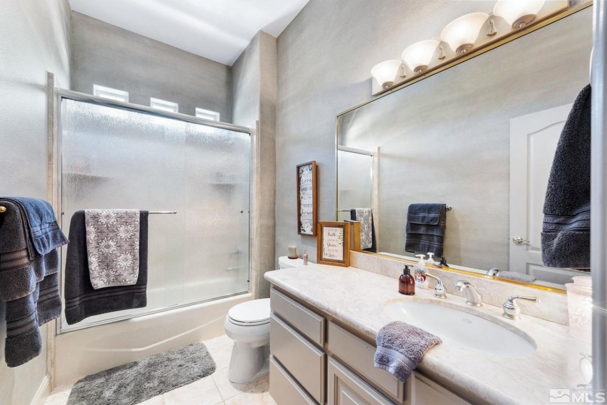 Bathroom with a toilet, sink and a walk-in shower.
