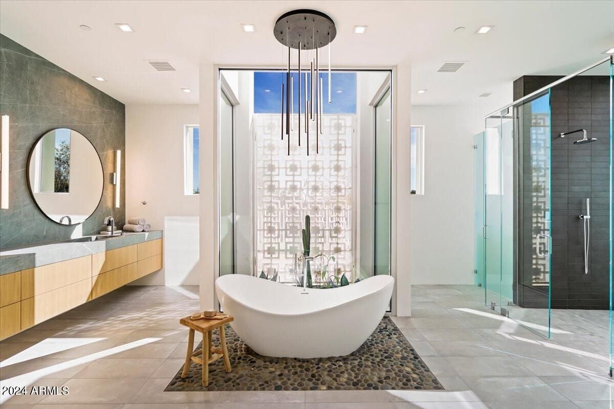 A bathroom with a sink, mirrors, bathtub, shower room, and tiled floor.