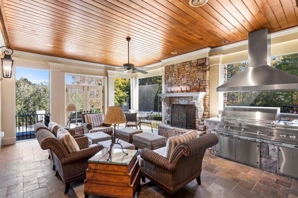 Covered patio with grill area and a fireplace.