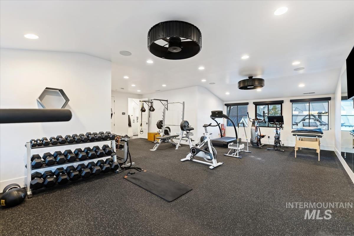 Home gym with workout equipment and custom lights.