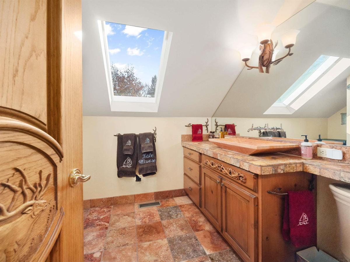 Bathroom with a sink, mirror and a skylight.