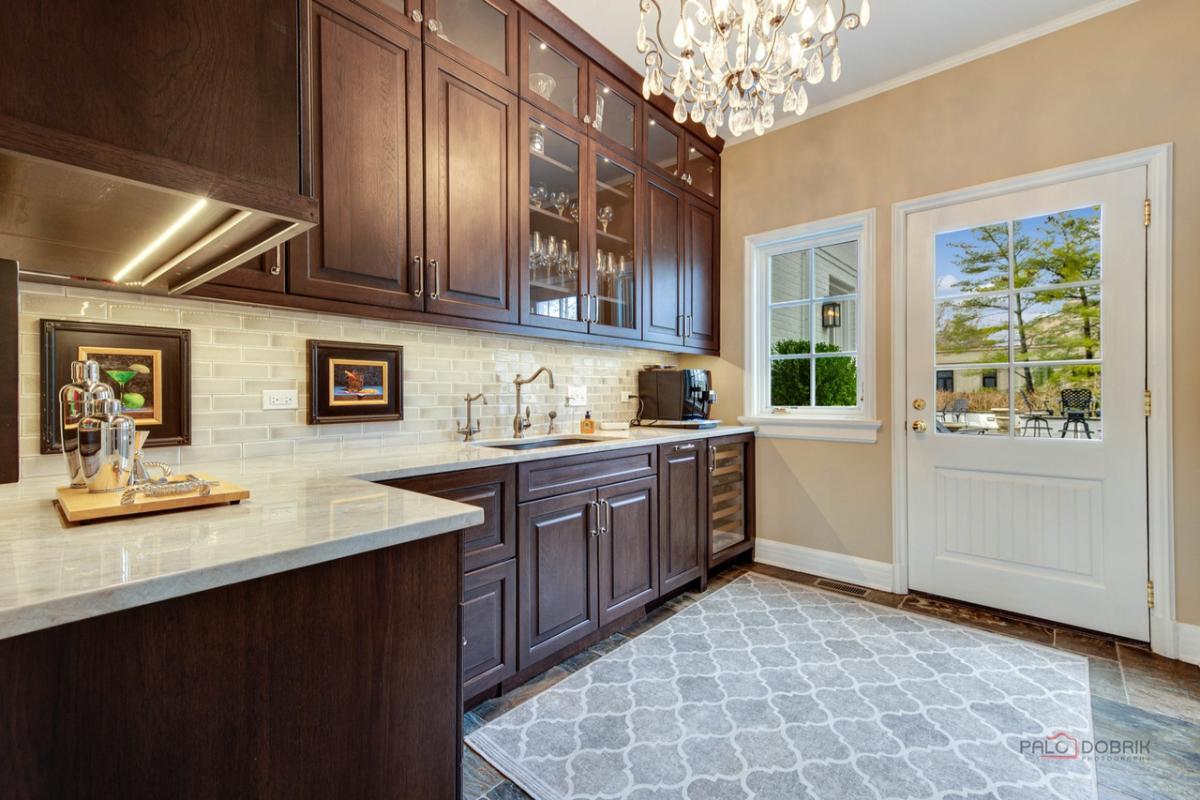Kitchen with a sink, chandelier and custom cabinets.