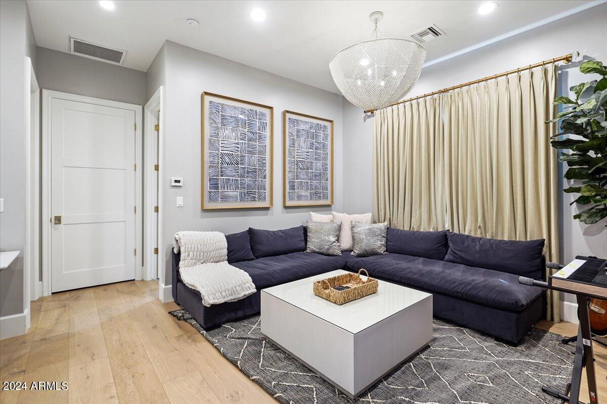 Sitting room with couches, large rug and wooden floor.
