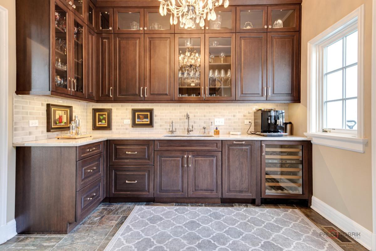 Kitchen with a sink, chandelier and custom cabinets.