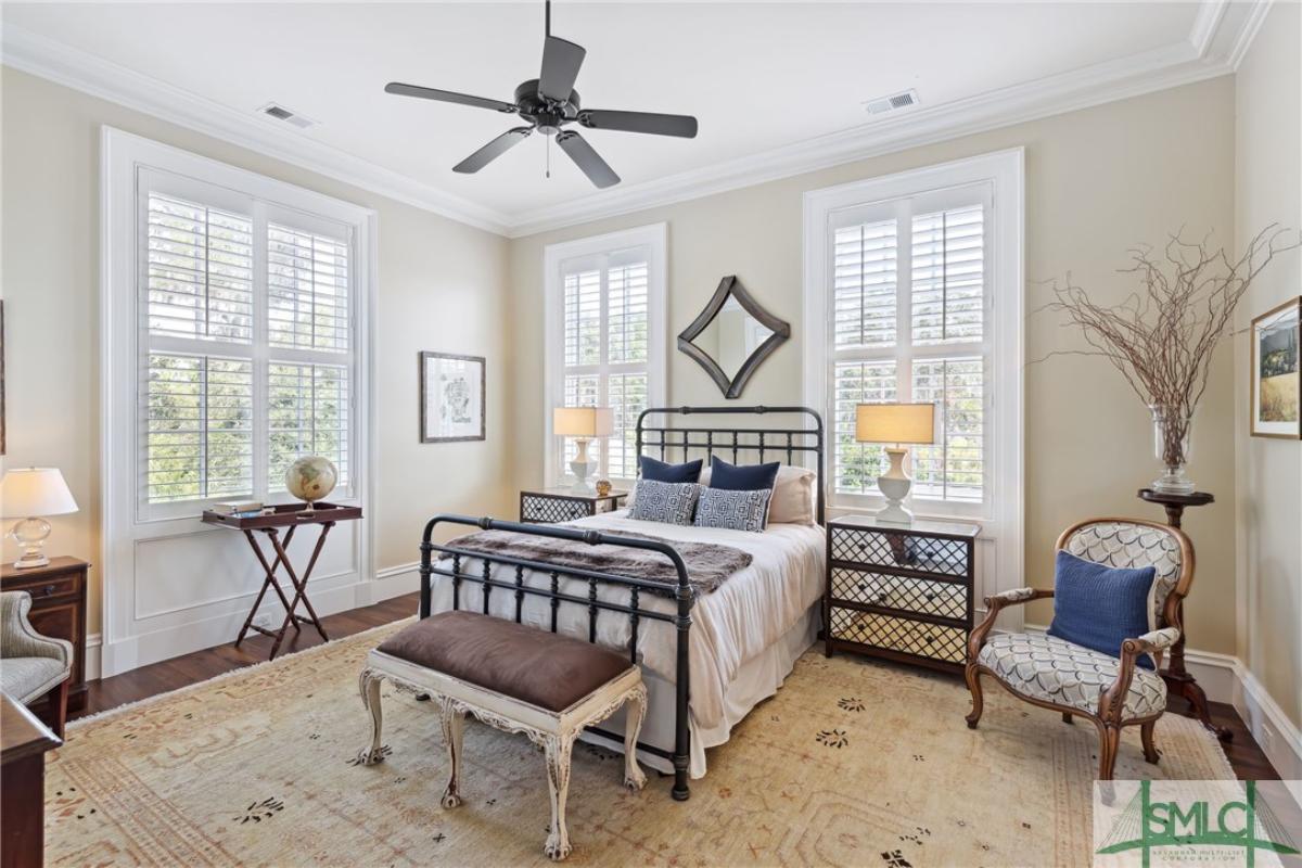 Bedroom with wood flooring and a large rug.