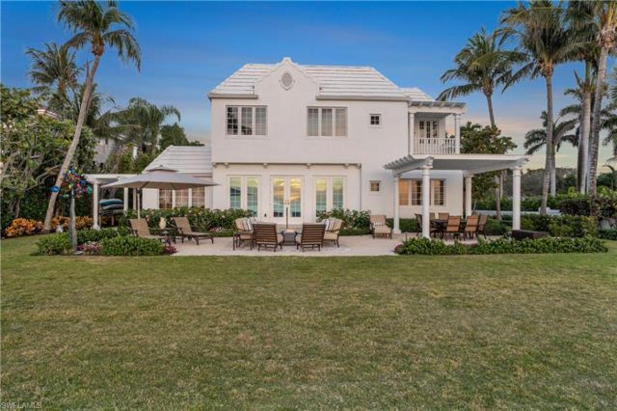 Rear view of the property with a large green lawn.