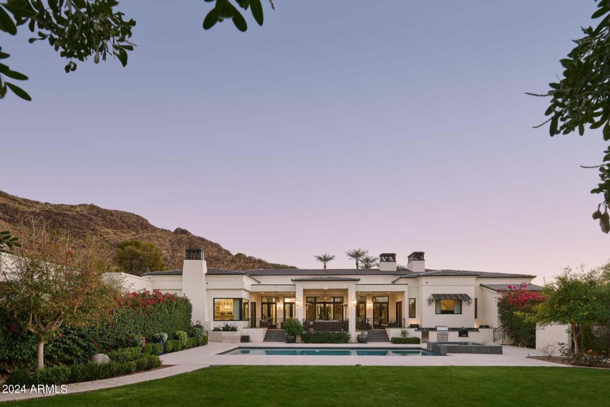 Backyard with a pool and a large green lawn.