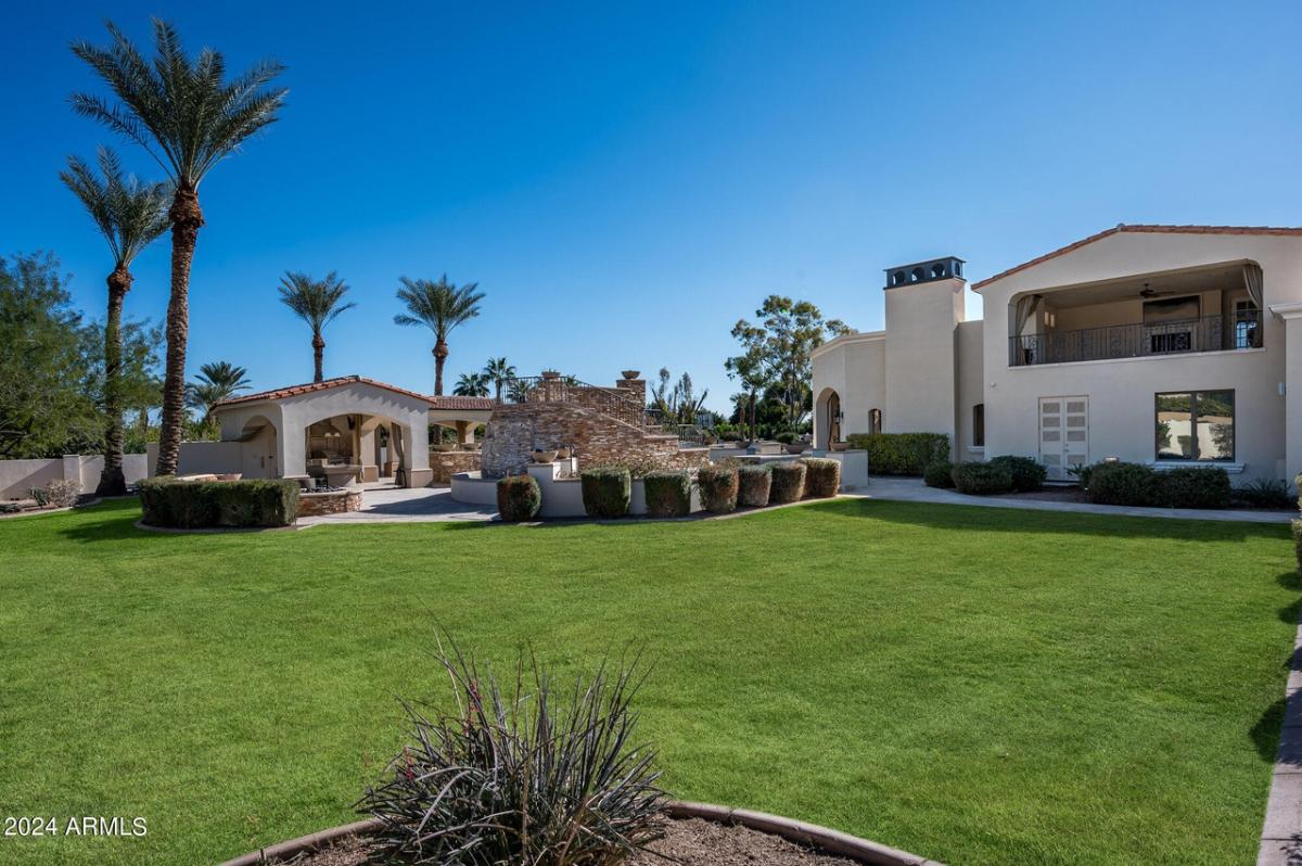 Backyard with a large green lawn.