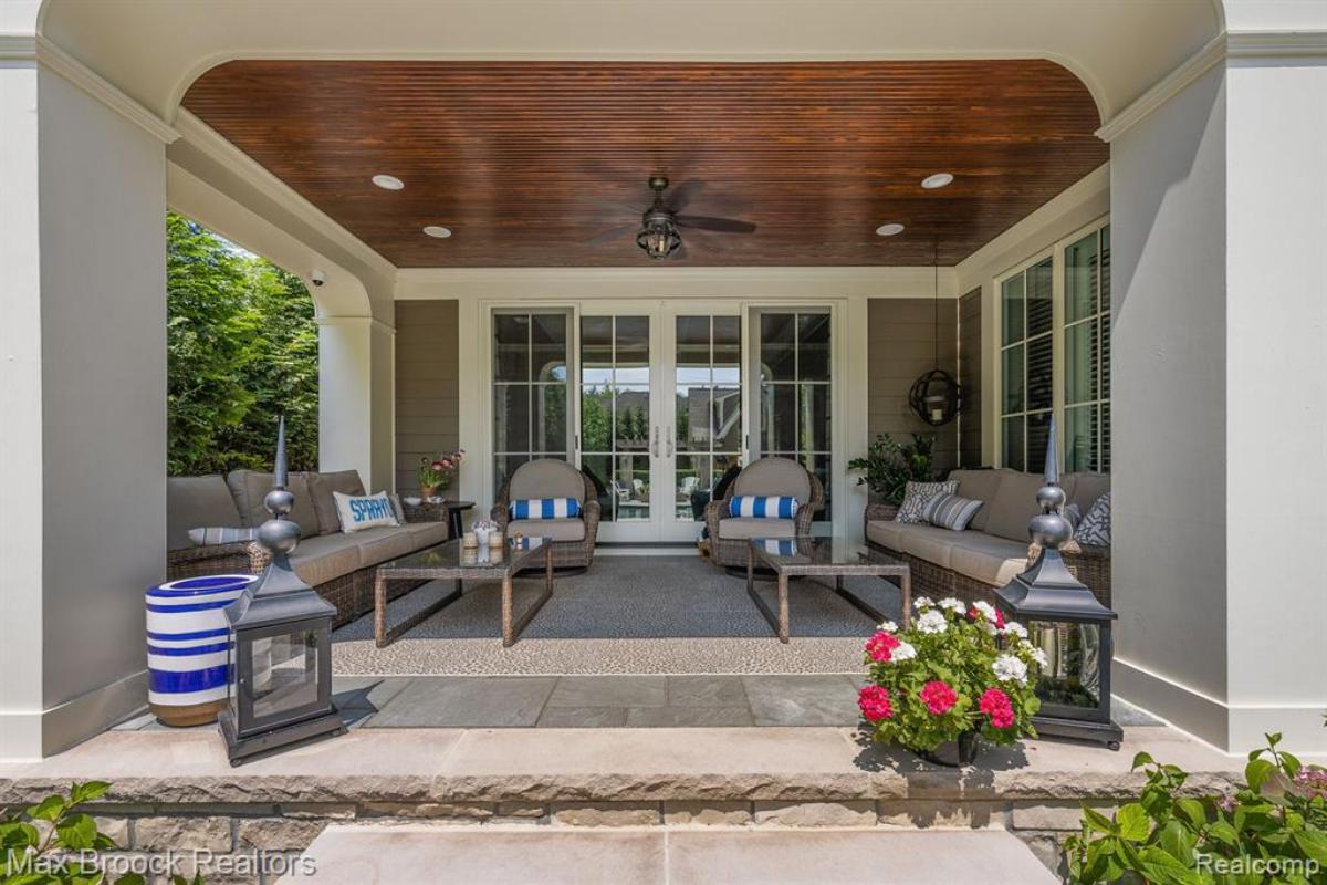 Covered patio with couches and chairs.