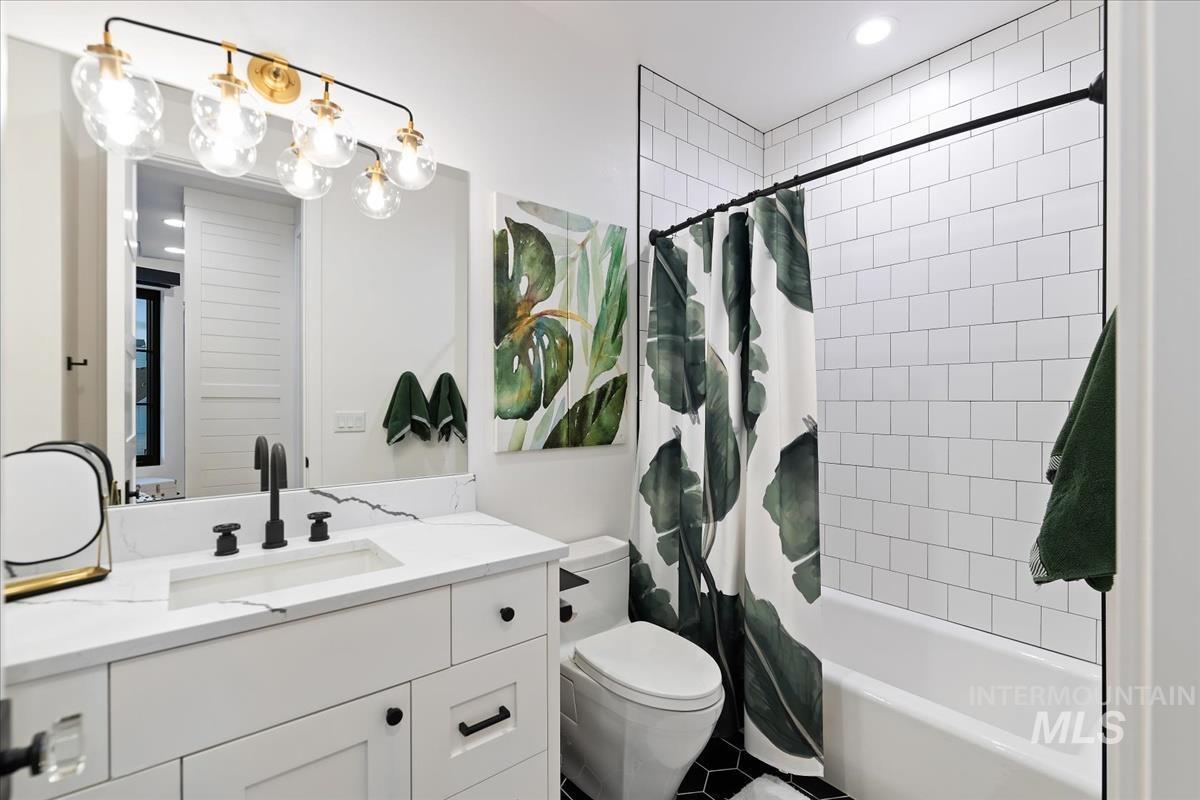 Bathroom with a sink, mirror, soaking tub and a toilet.
