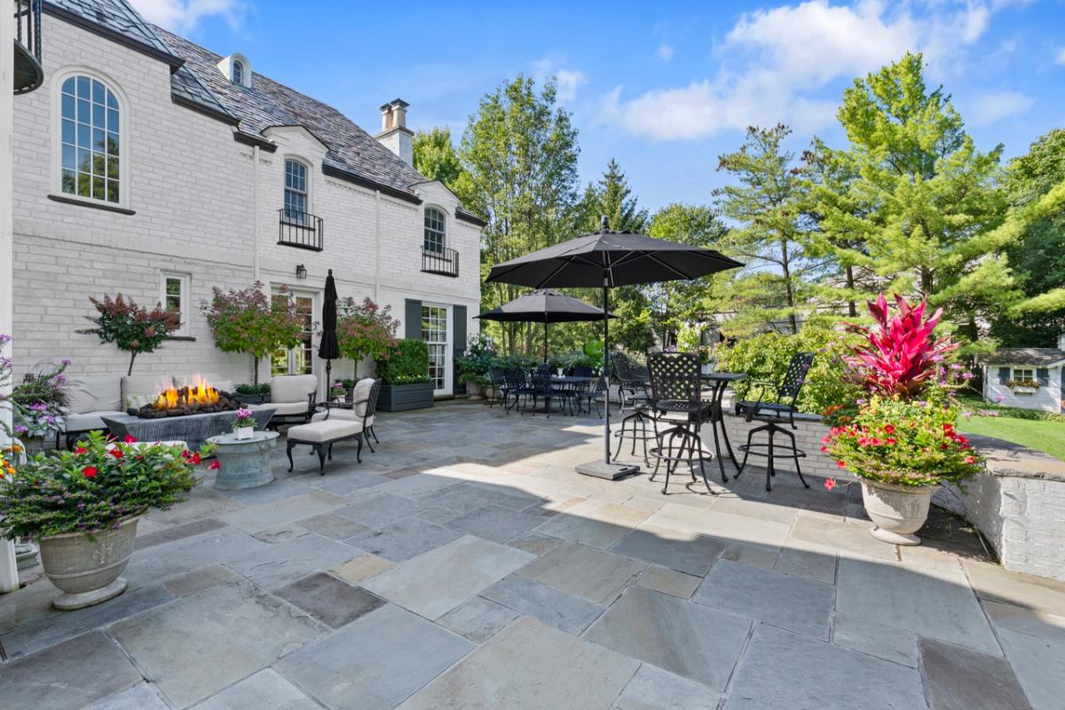Patio with tables, chairs, fire pit and umbrellas.