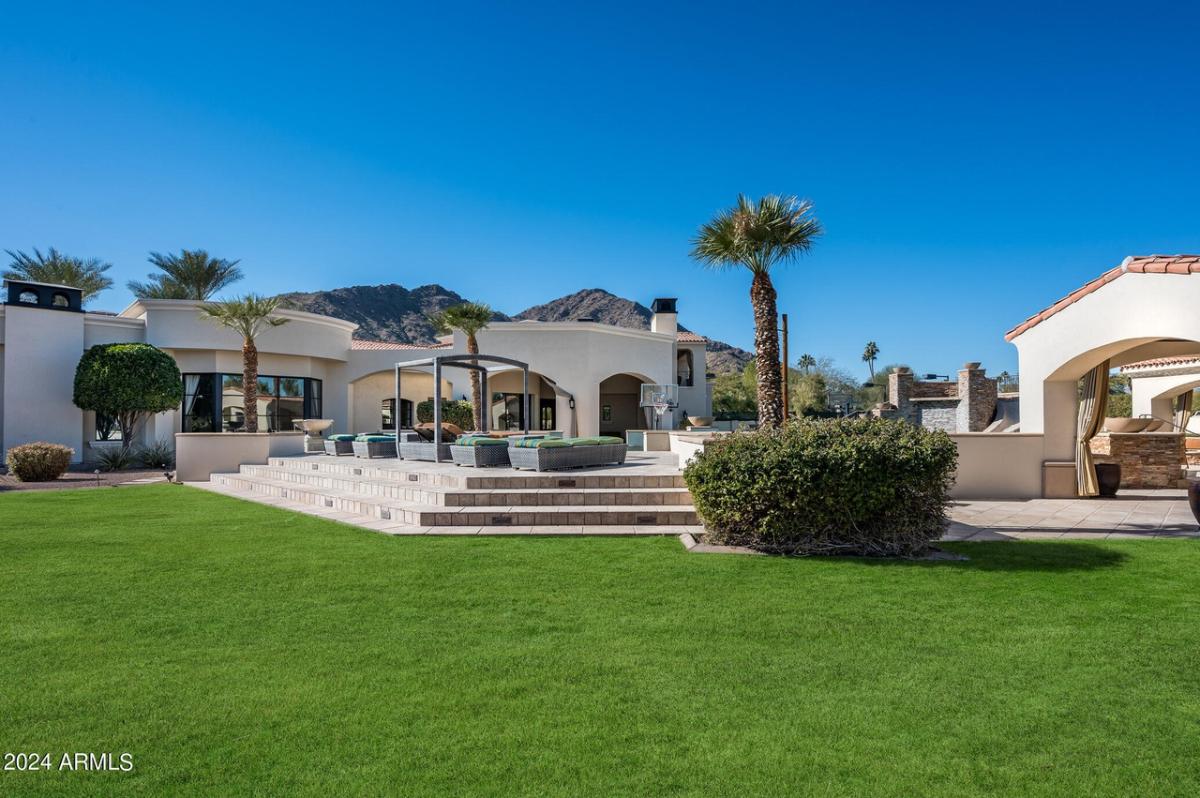 Backyard with a large green lawn.