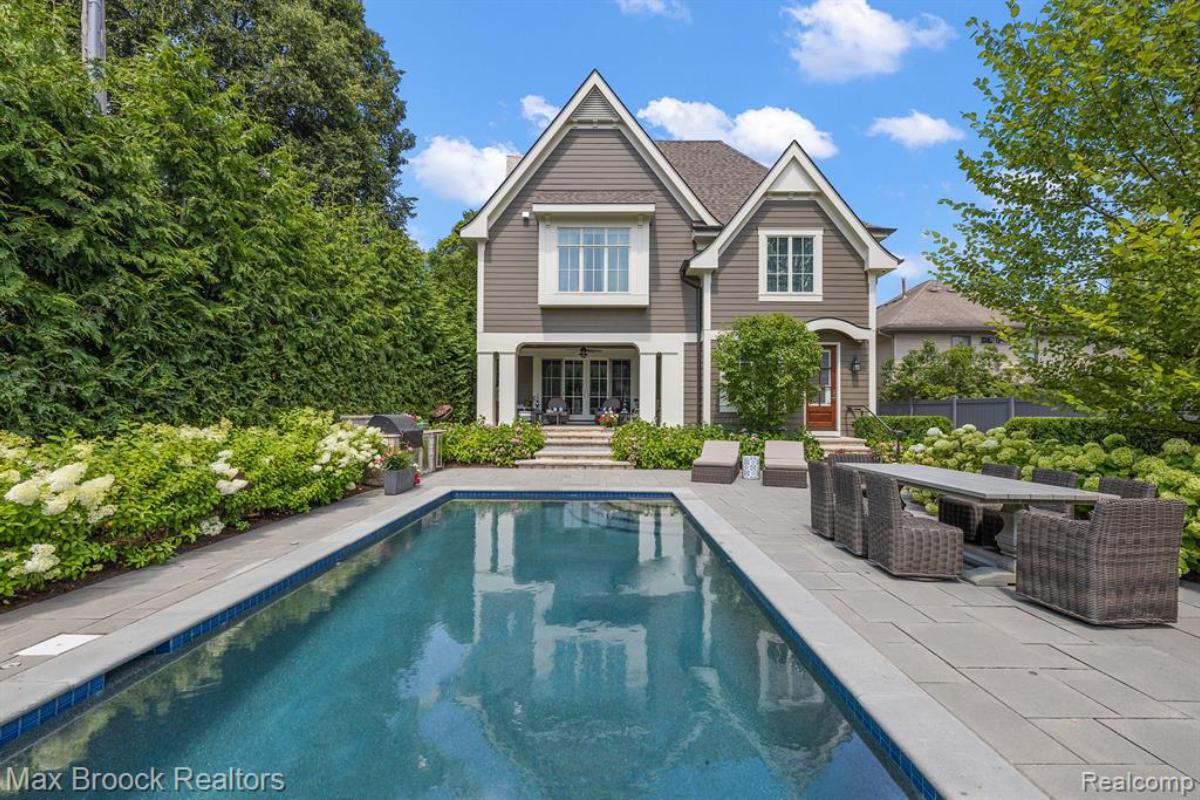 Pool with a patio and lounge chairs.