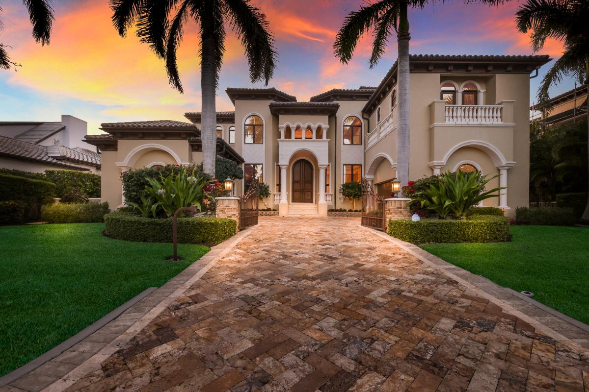 Covered front entry of the mansion with a wooden door and a driveway.