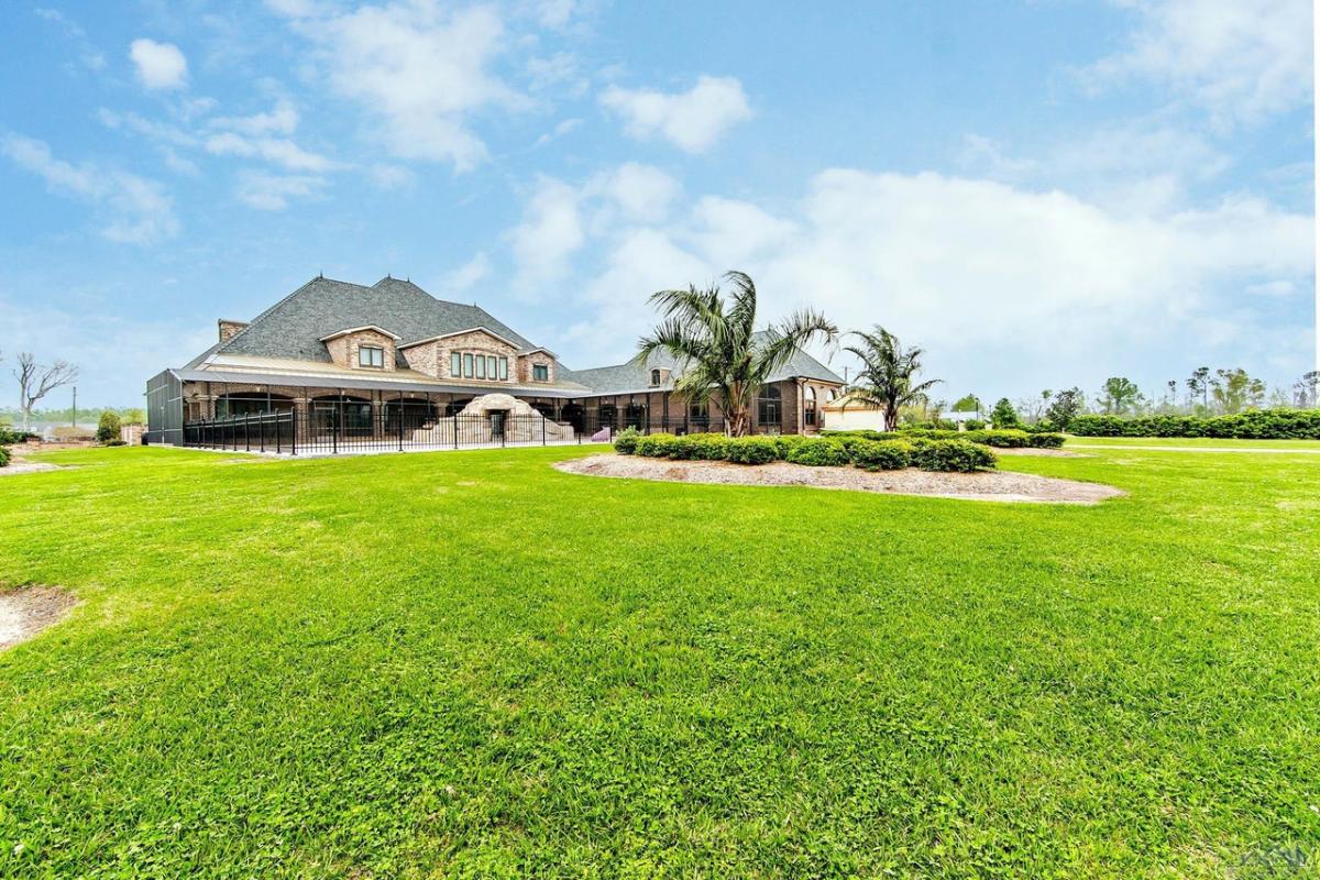 Exterior view of the mansion with a large lawn.