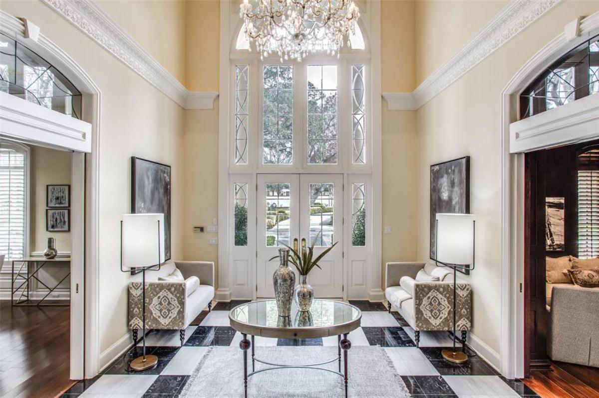 Foyer with chairs and a chandelier.