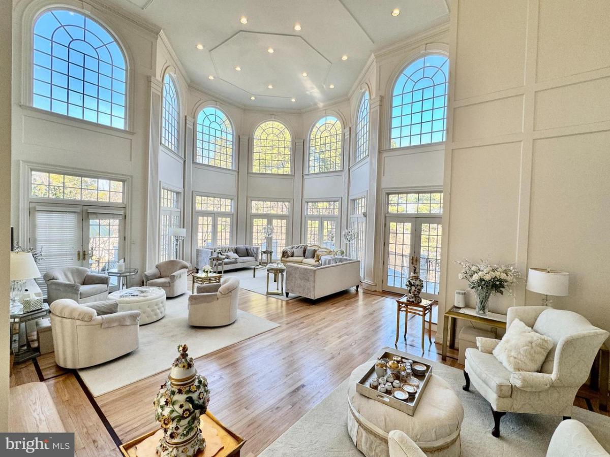Living room with tables, chairs, couches and wood flooring.