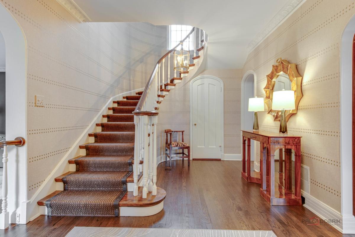 Staircase with a wooden floor and a white wall.
