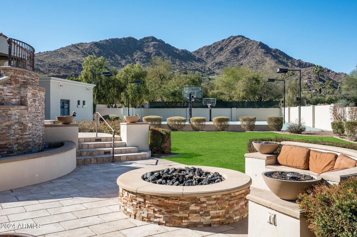 Patio with a fire pit, couch and a view of the mountains.