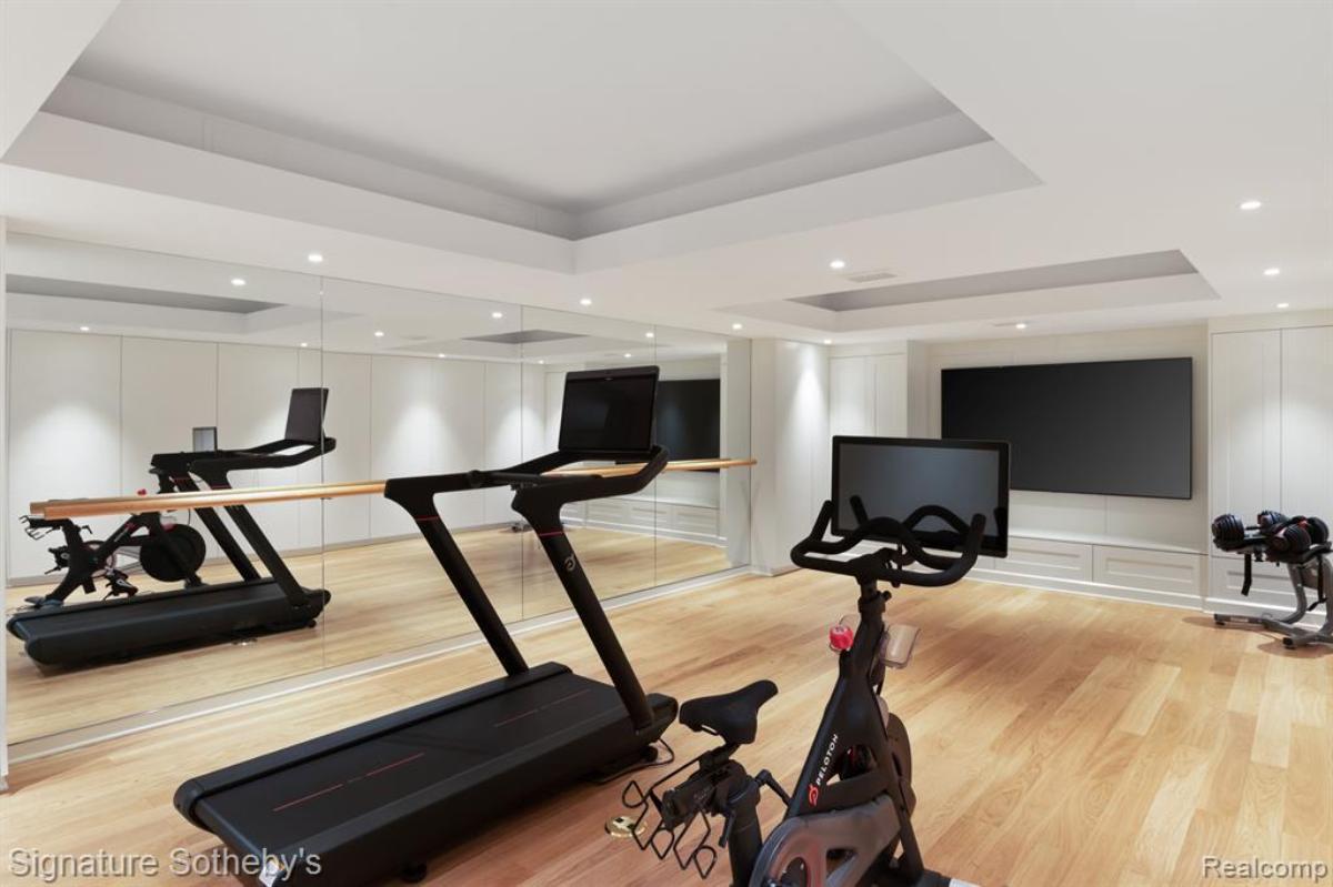 Home gym with workout equipment and custom lights.