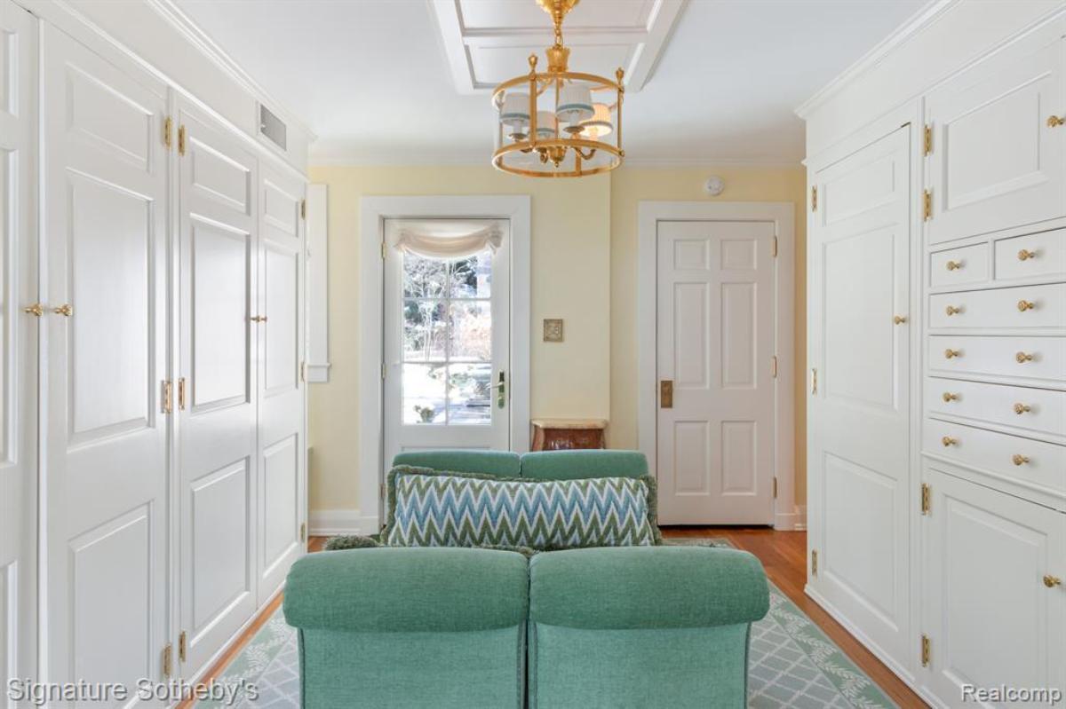 Walk-in closet with white cabinets and drawers.