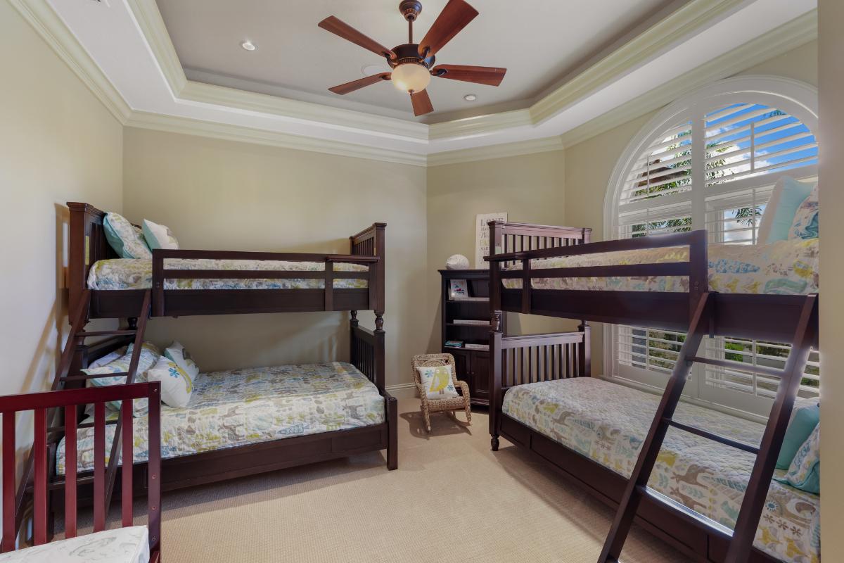 Bedroom with a bed bunks, carpet flooring and large glass windows.