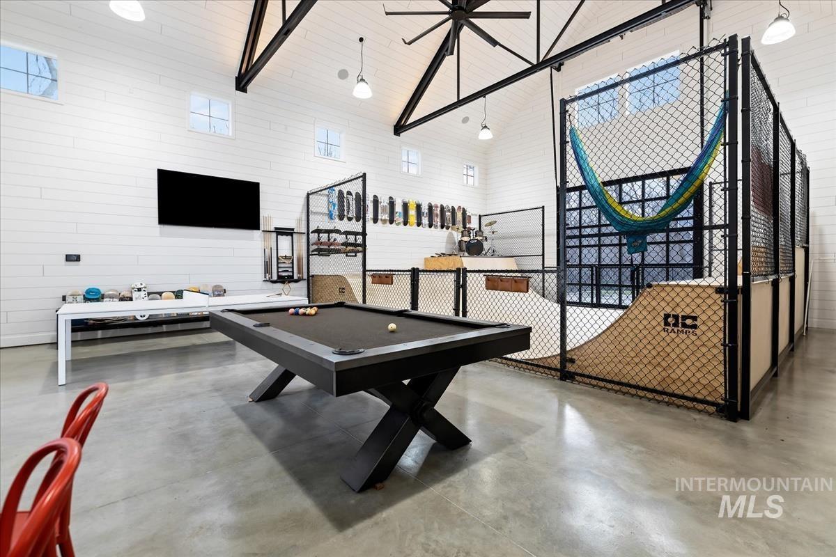 Entertainment room with a billiard table and a half pipe for skateboard.