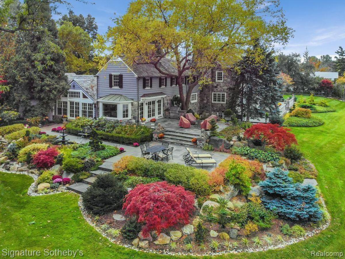 Exterior view of the house with a garden and a large lawn.