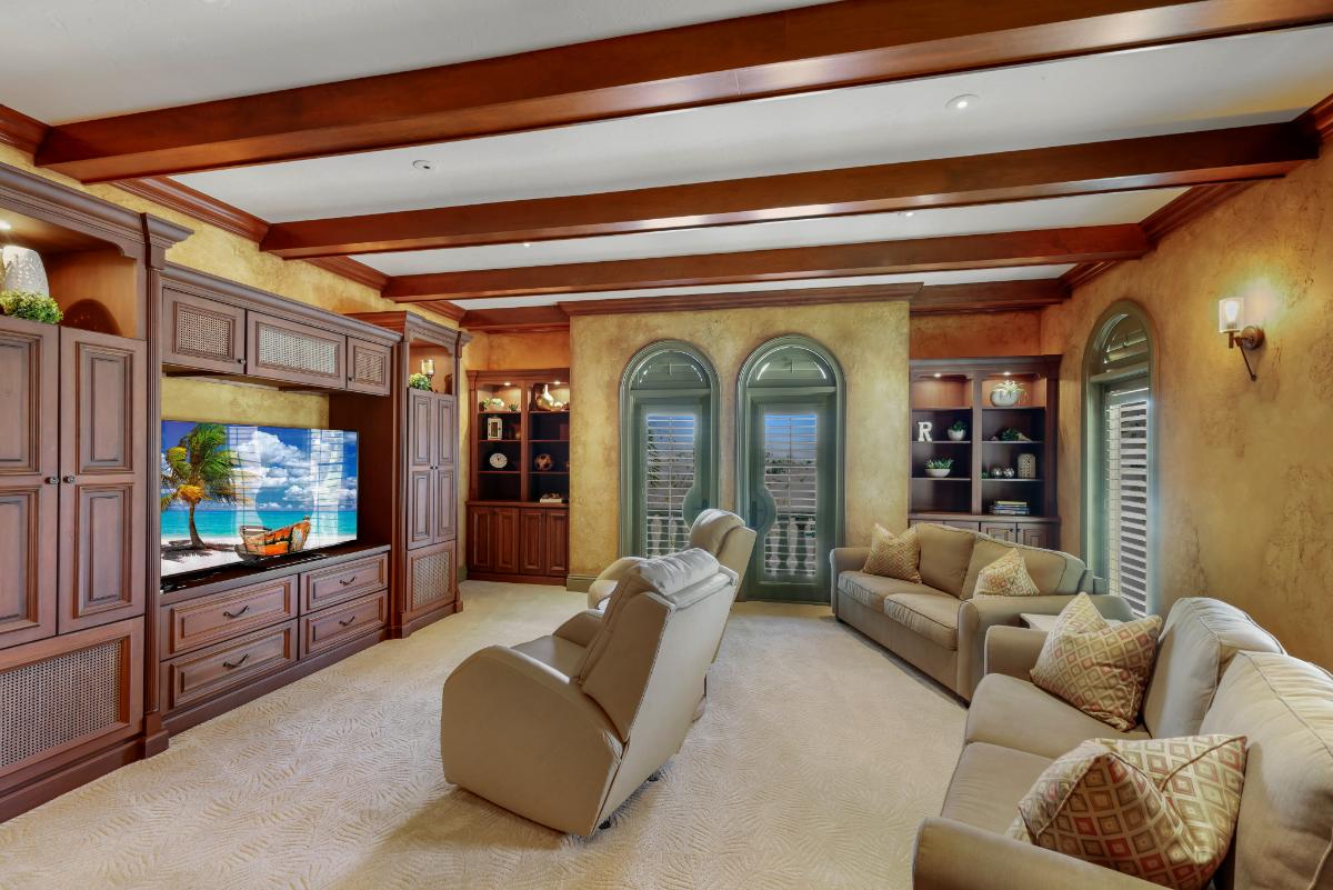 Media room with couches, TV, custom lights, and a carpet flooring.