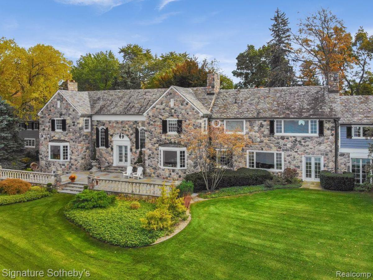 Exterior view of the property with a large green lawn.