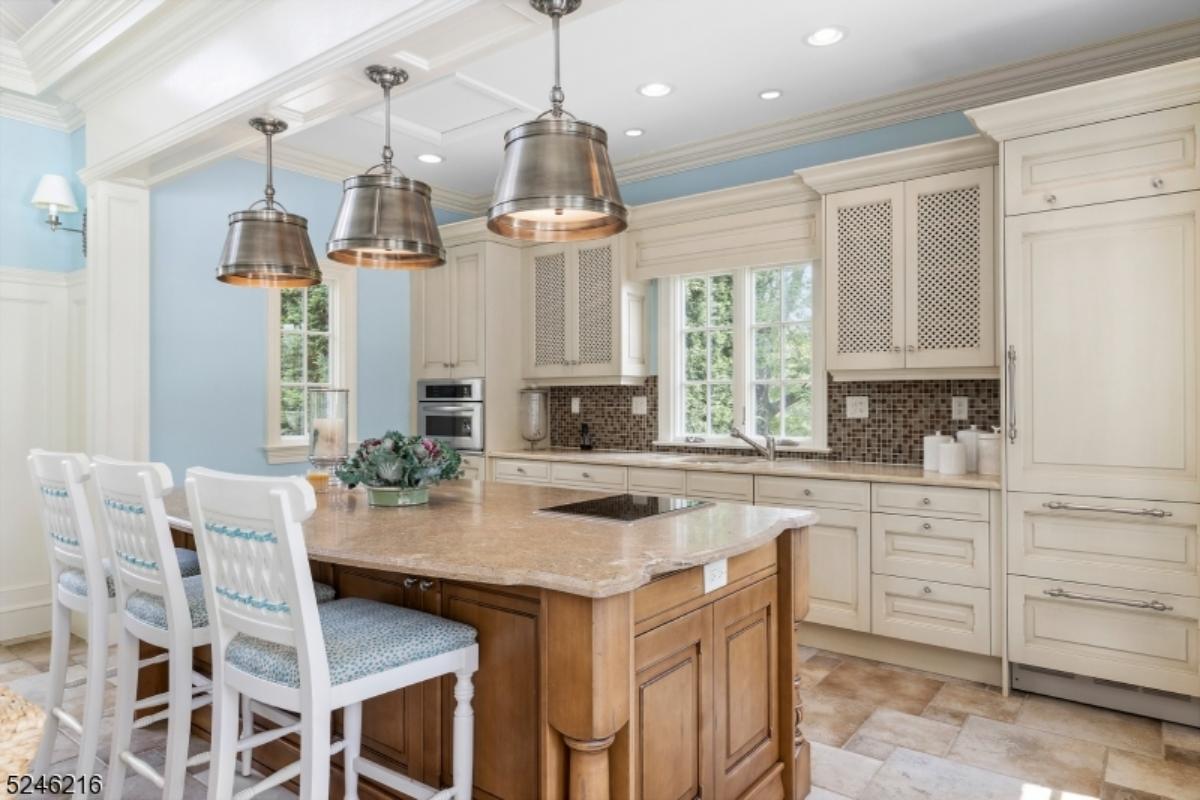 Kitchen with a large island, custom lights and custom cabinets.