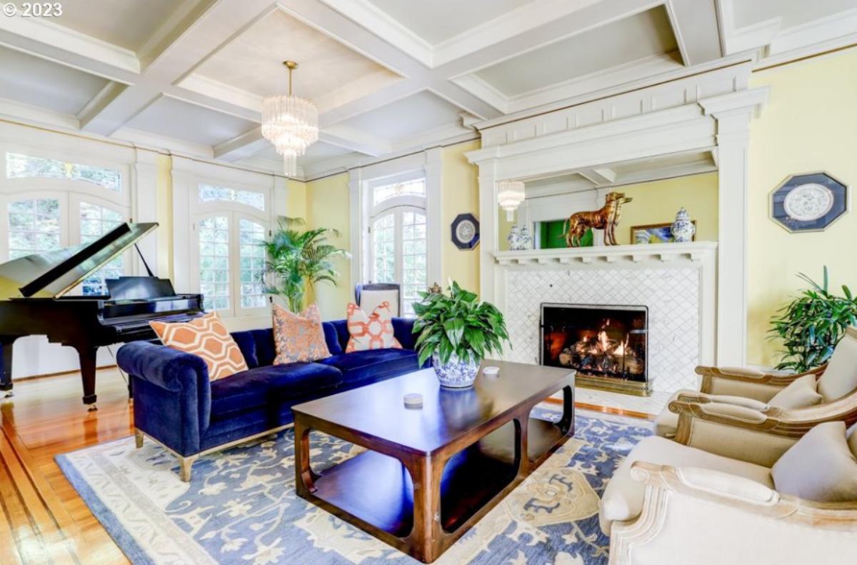 Living room with a piano, couch and a fireplace.