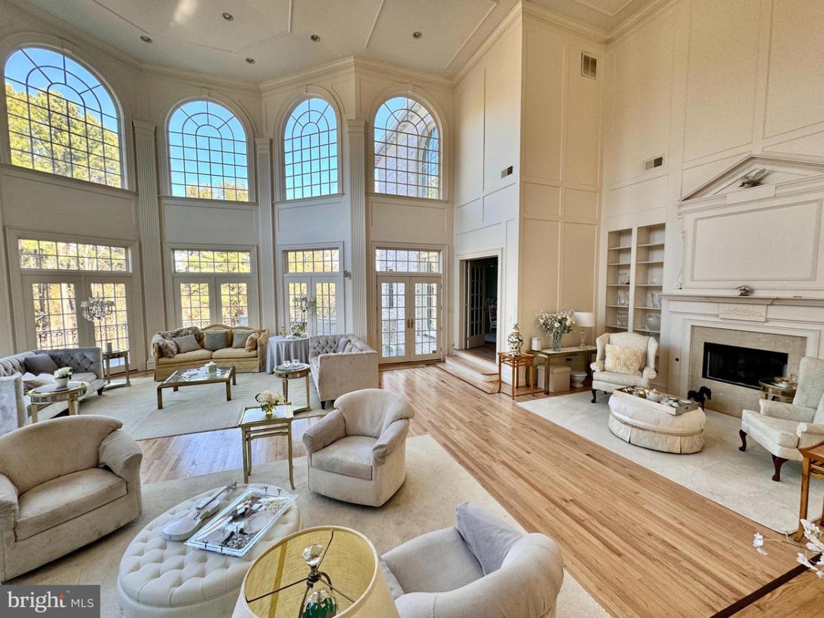 Living room with tables, chairs, couches and a fireplace.