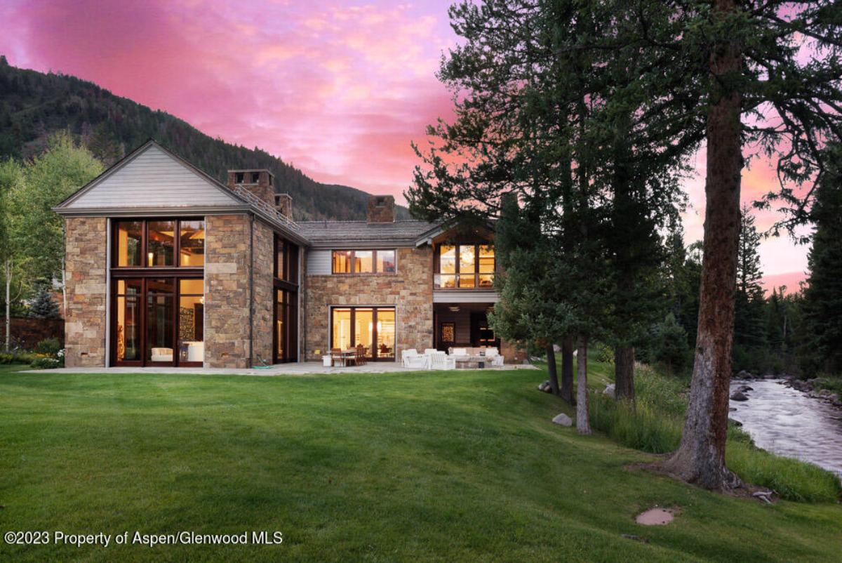 Exterior view of the mansion with a large green lawn.