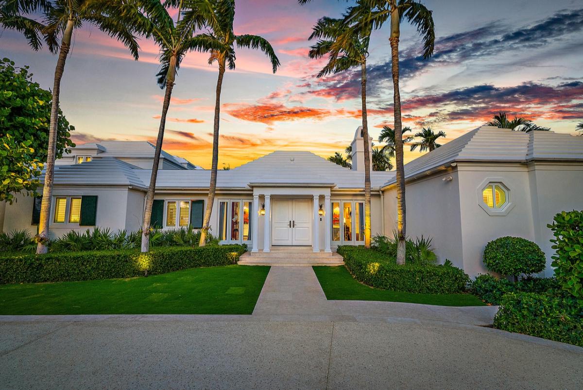 Covered front entry of the real estate with wooden doors.