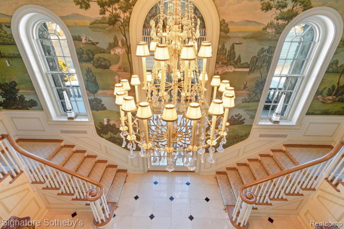 Foyer with staircase and a chandelier.