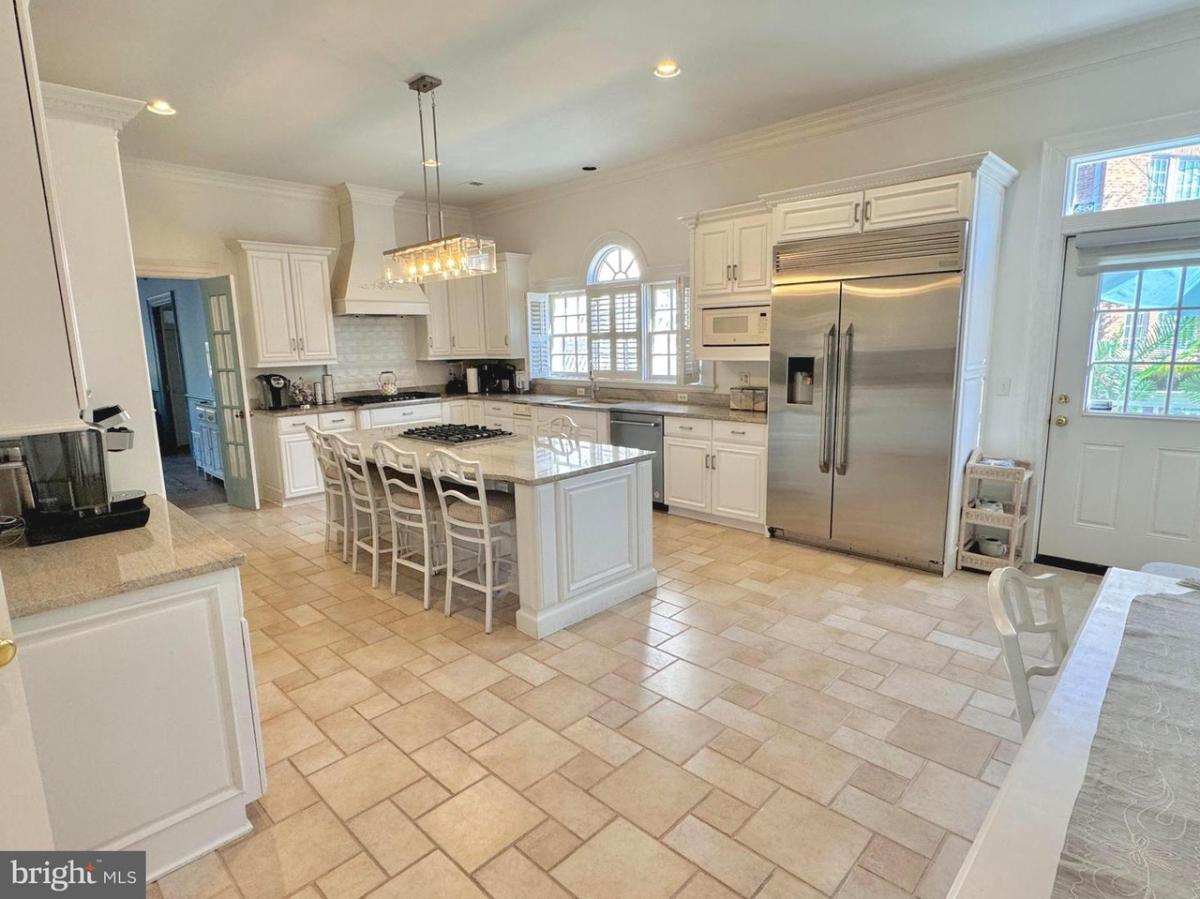 Kitchen with a large island, stainless-steel appliances and custom cabinetry.