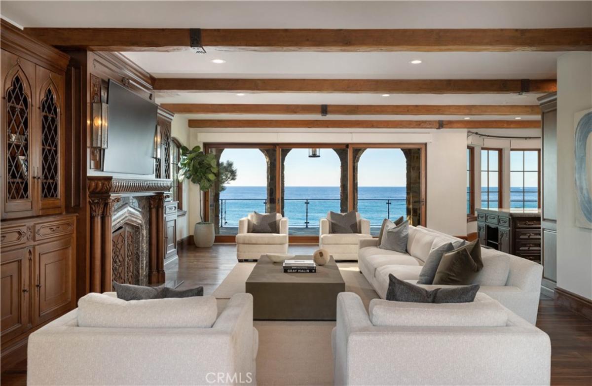 Living room with a couch, chairs, TV, custom lights and glass doors.