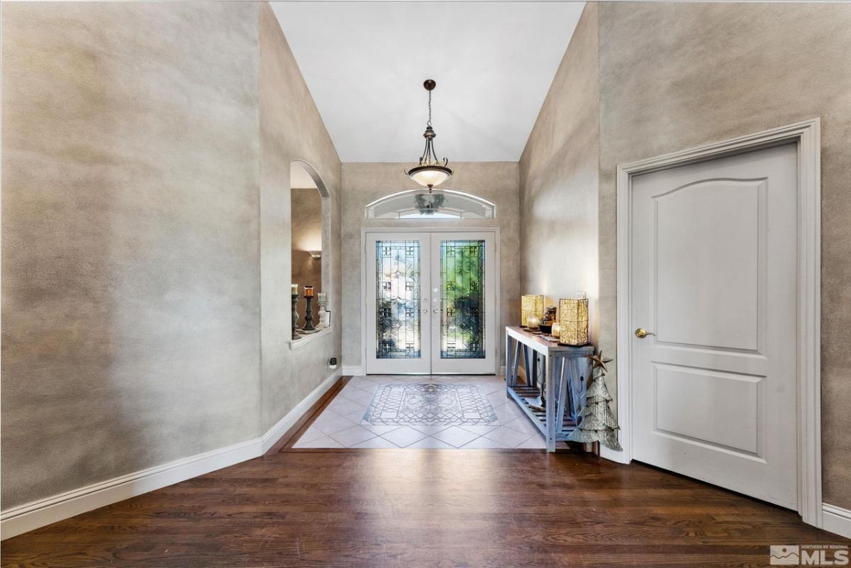 Foyer with a glass doors and a chandelier.