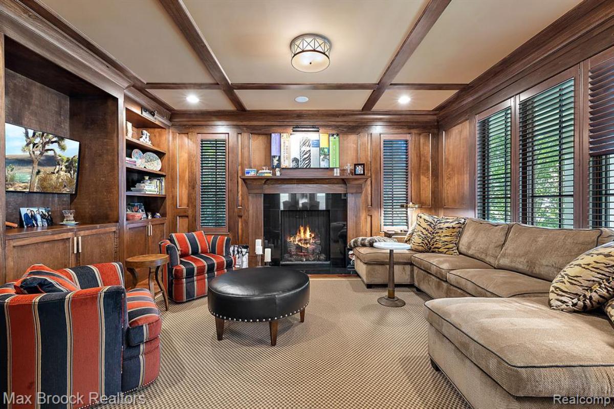 Living room with a couch, glass windows and a fireplace.