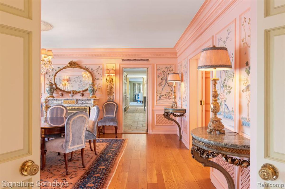 Hallway with pink walls and a wooden floor.