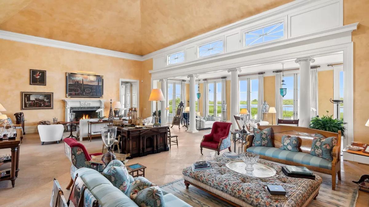 Living room with couches, chairs, fireplace and glass doors.