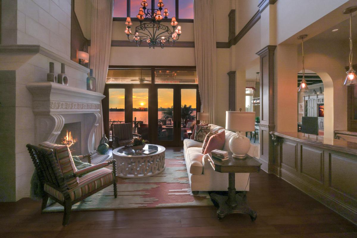 Living room with a couch, fireplace, wooden floor and a large rug.